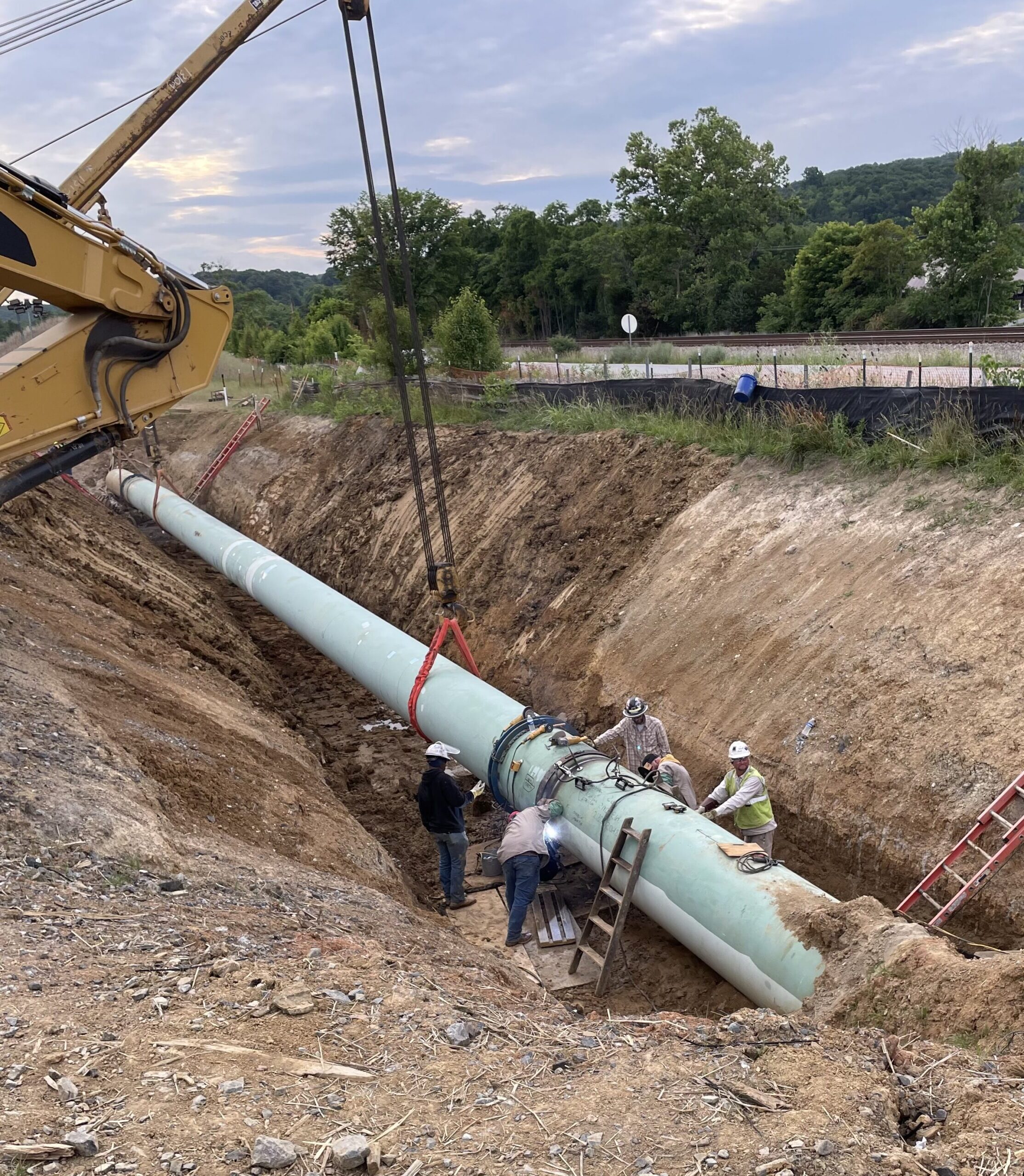 Five men working on a large gas pipeline