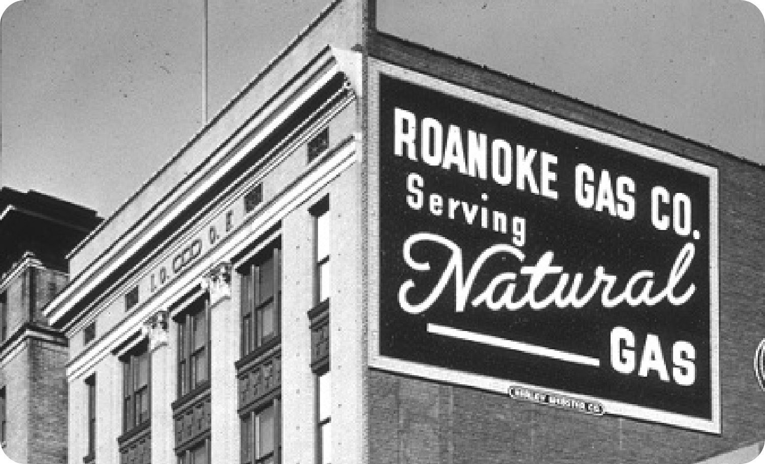 Black and white photo of the Roanoke Gas Company sign on the side of a building